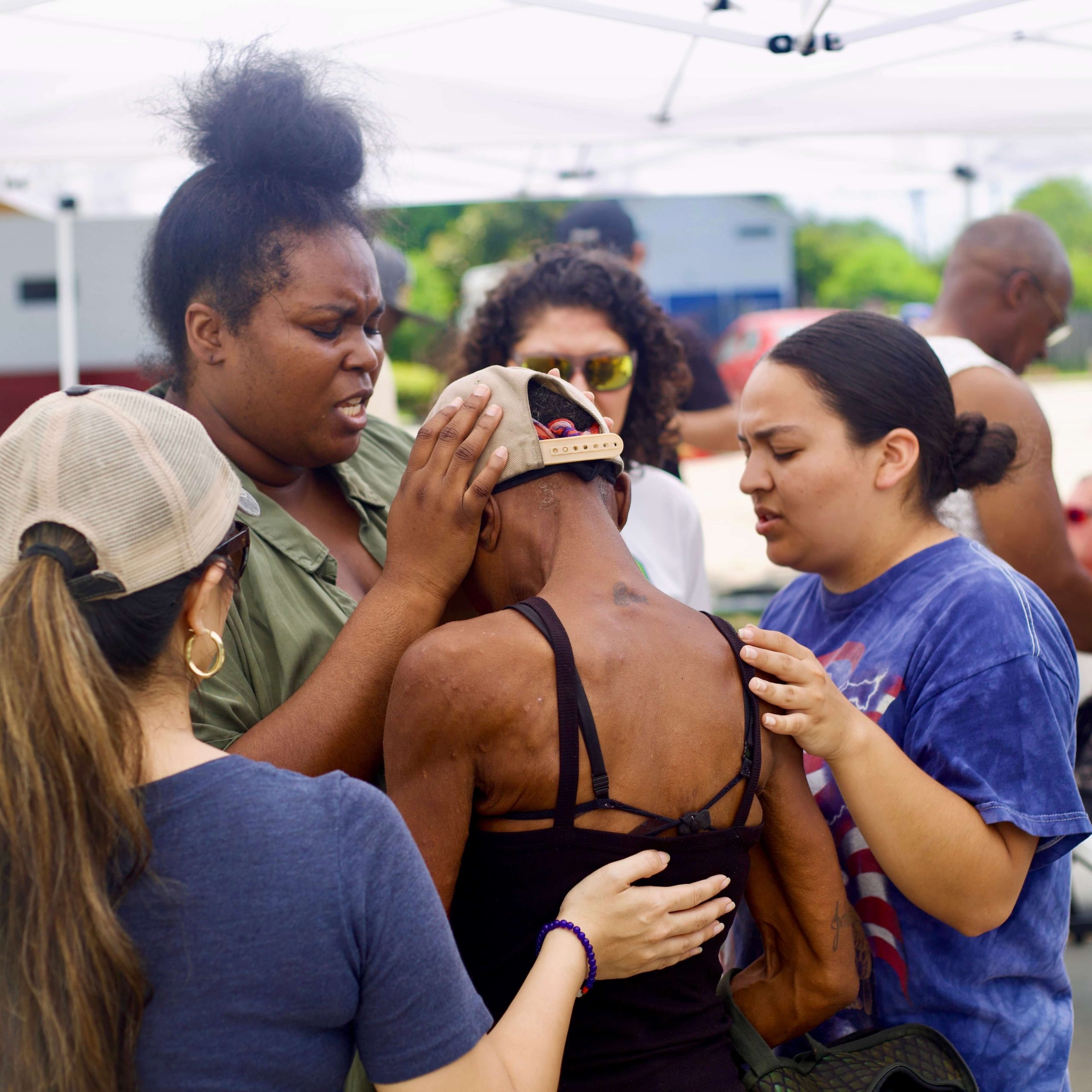 Photo May 14 2026, 1 19 38 PM 2 Nations School summer internship students praying over a member of the Third Ward community during an outreach event