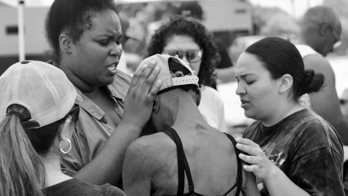 Praying over a woman from the community at a Nations House of Prayer outreach